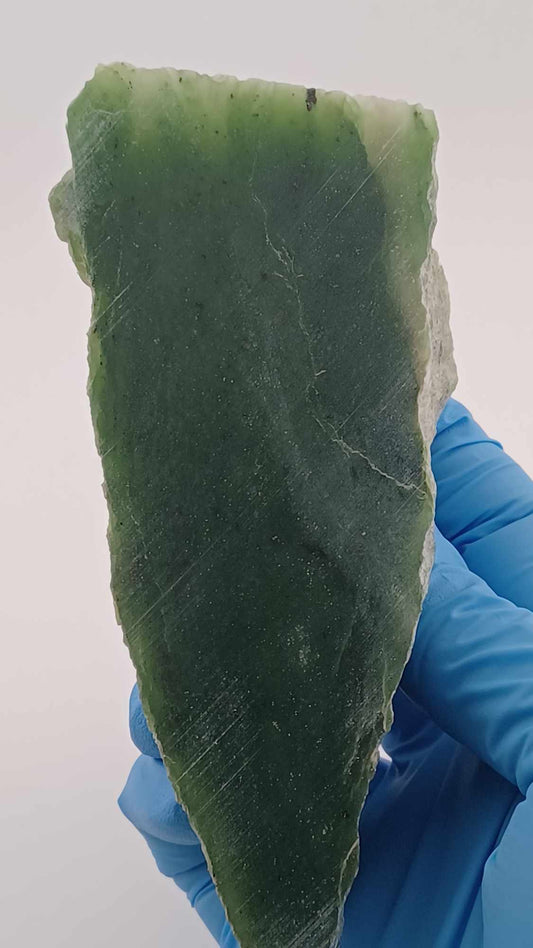 High-resolution image of a Grade-B Cassiar nephrite Jade Triangle cut 367g showcasing its luminous, translucent green jade with intricate Colors of Light Transparent Green, from British Columbia Canada