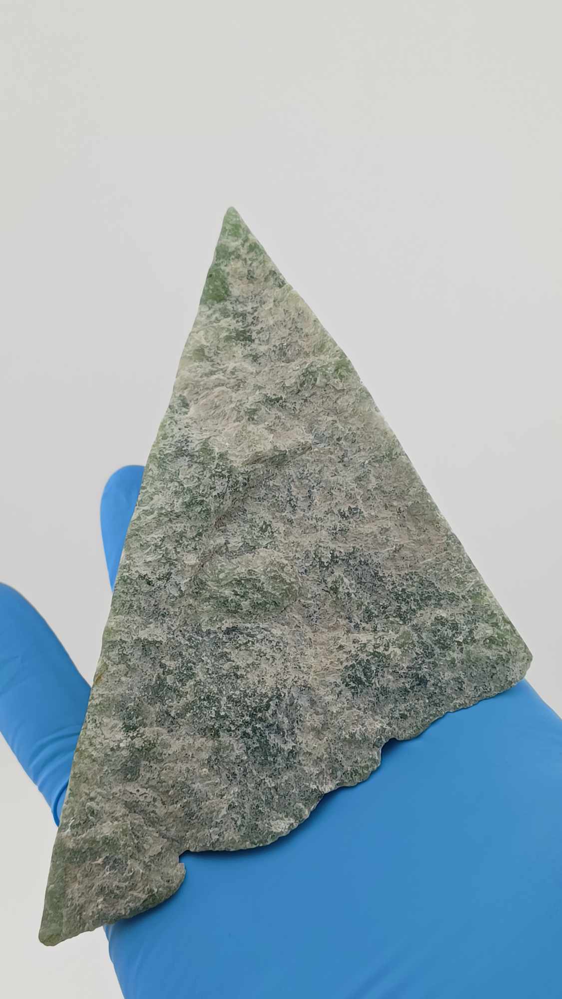 High-resolution image of a Grade-B Cassiar nephrite Jade Triangle cut 367g showcasing its luminous, translucent green jade with intricate Colors of Light Transparent Green, from British Columbia Canada